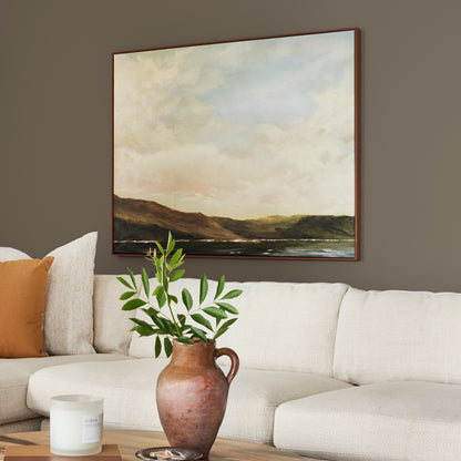 Mosswood paint featured in living room walls with large landscape picture above cream sectional and brown vase and greenery