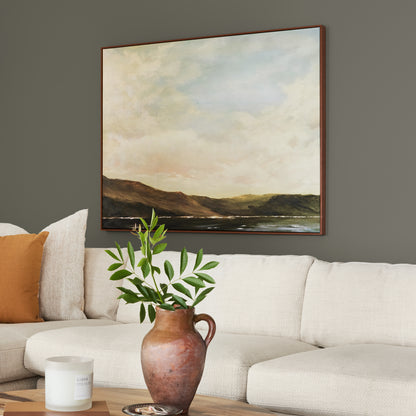 Trailhead paint featured in living room walls with large landscape picture above cream sectional and brown vase and greenery