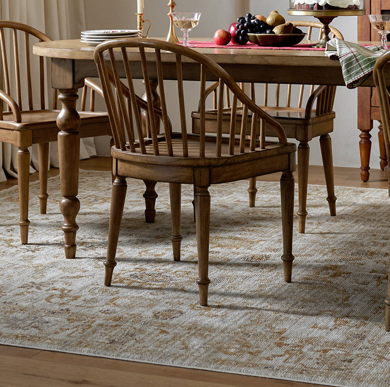 Wooden dining table and chairs set in a room with a rug.