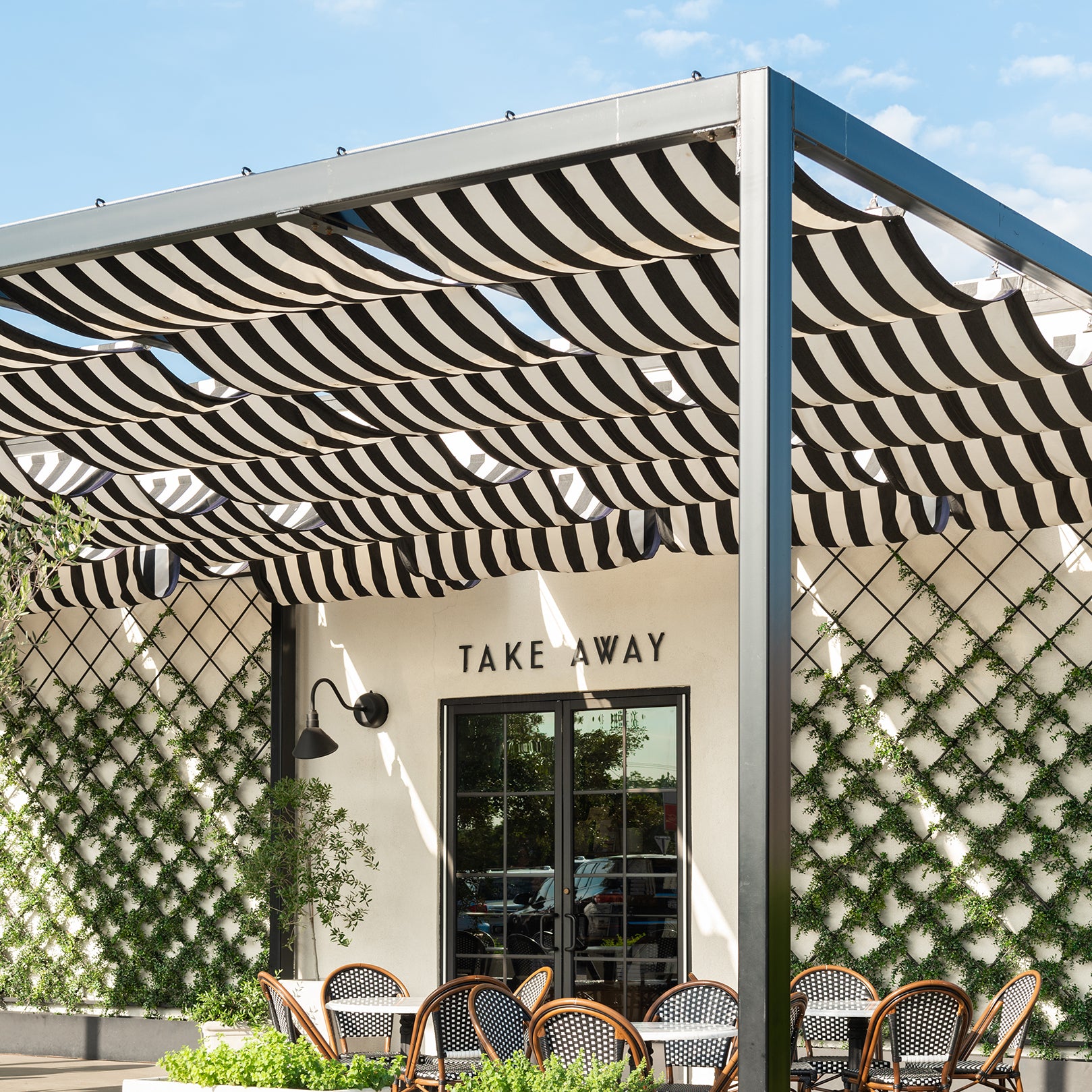 Magnolia Table restaurant exterior with striped awning and outdoor seating area