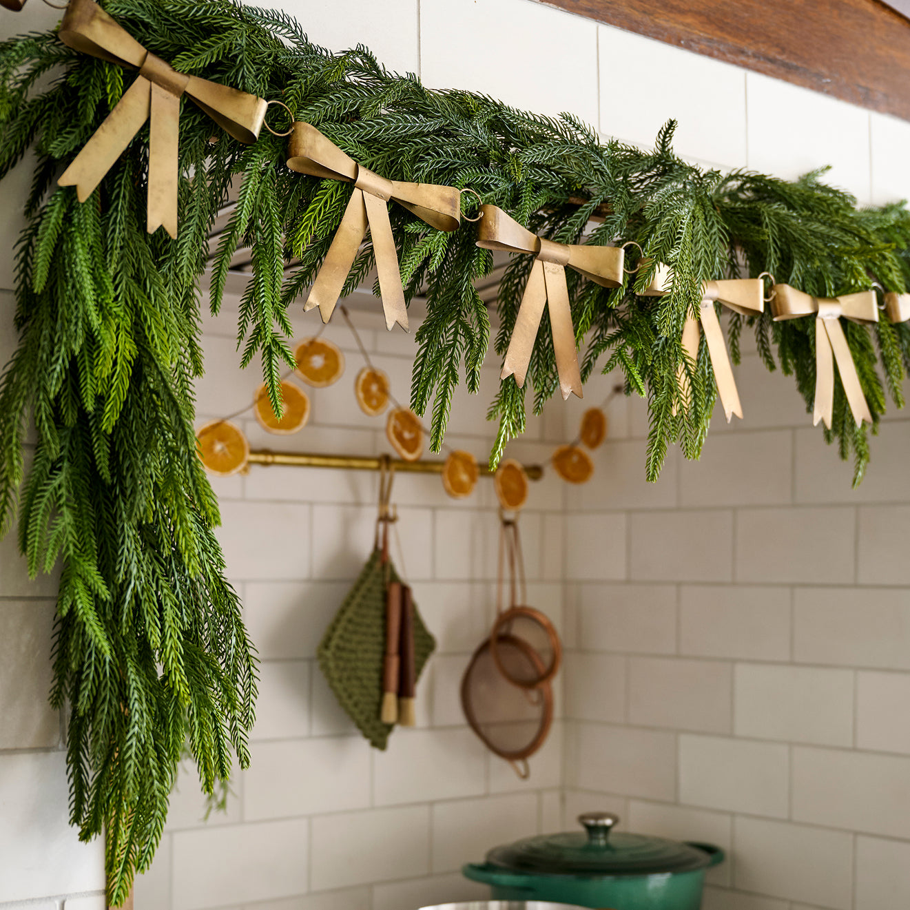 green garland hung above a range with gold metal bow garland on top.  