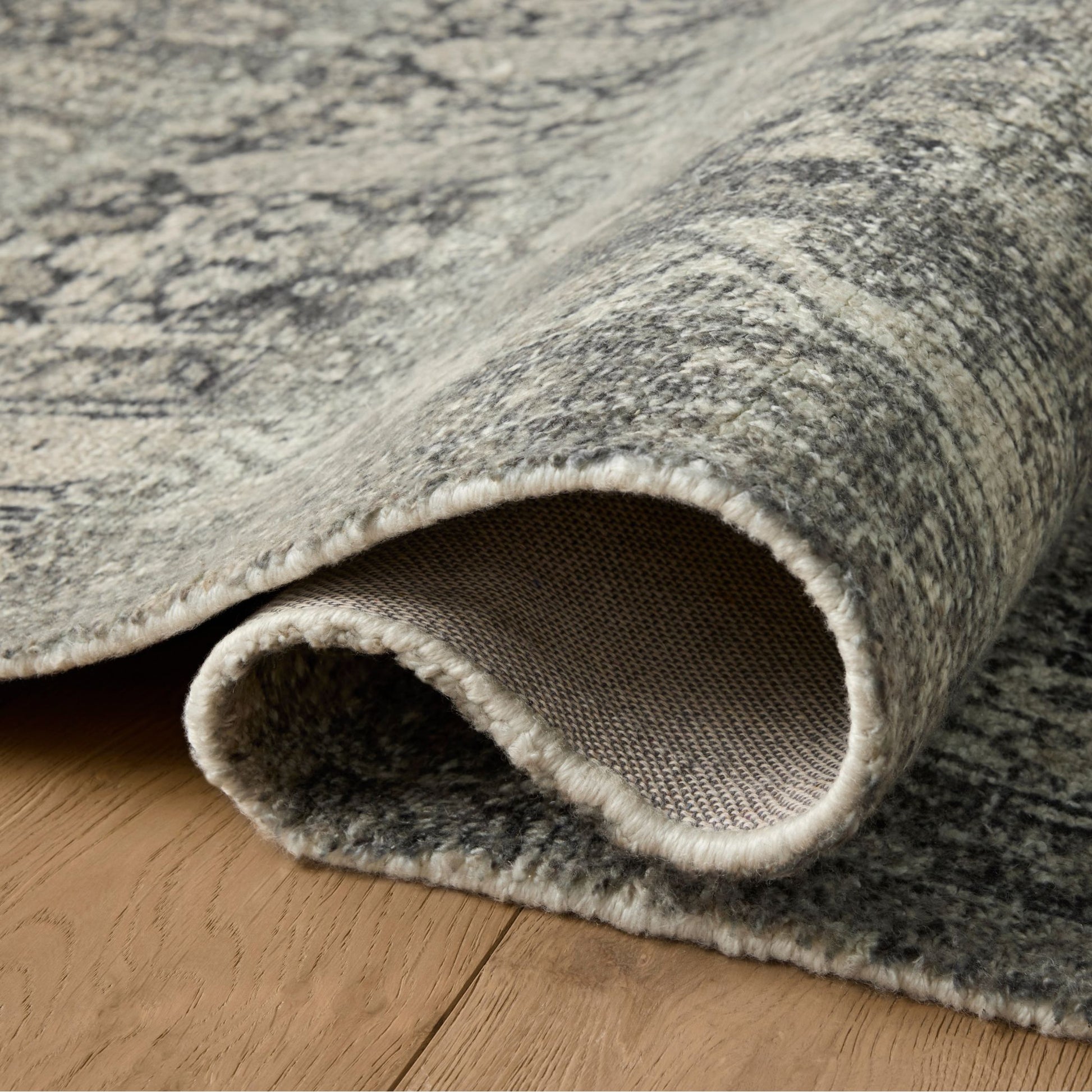 Wimberly Granite Cream Rug shown rolled/folded