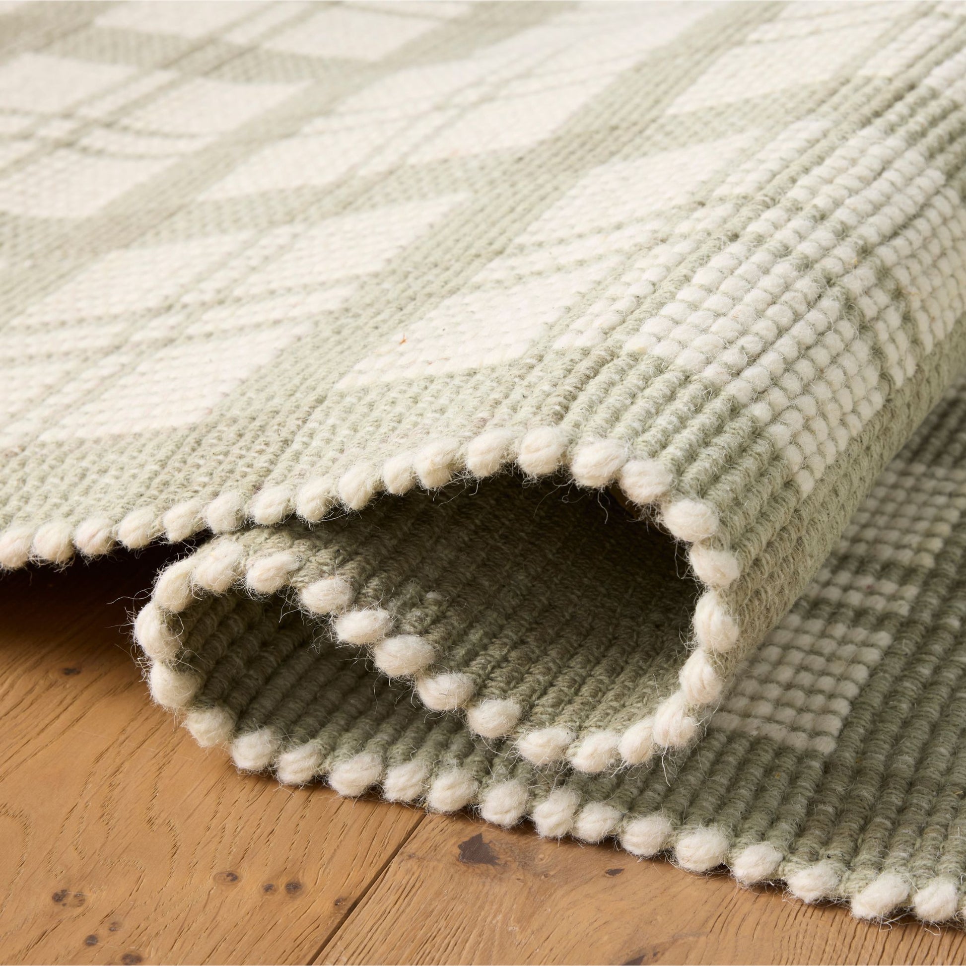 Ryder Sage Ivory  Rug shown rolled/folded