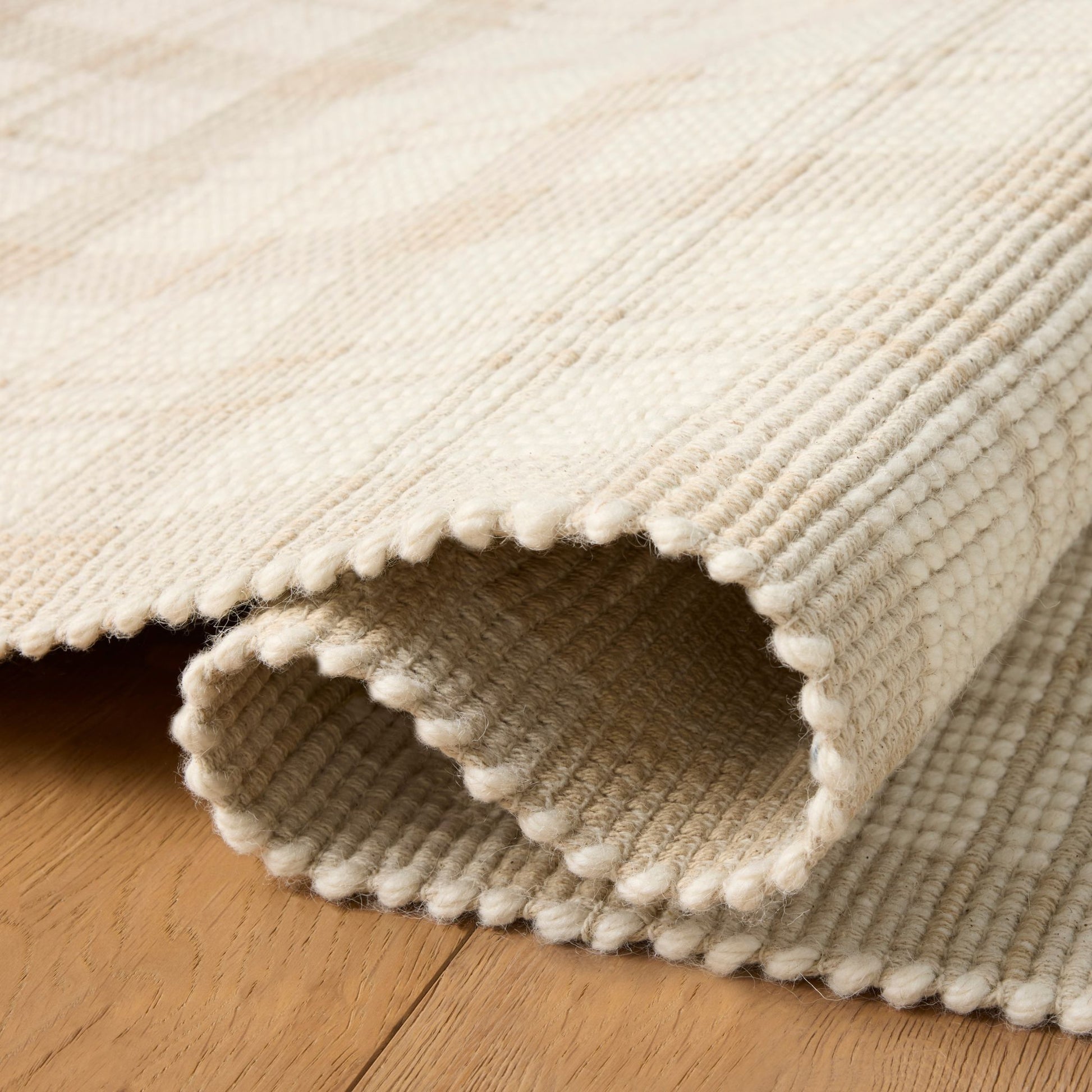 Ryder Beige Ivory Rug shown rolled/folded
