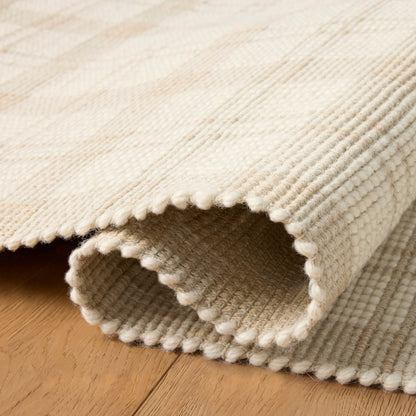 Ryder Beige Ivory Rug shown rolled/folded