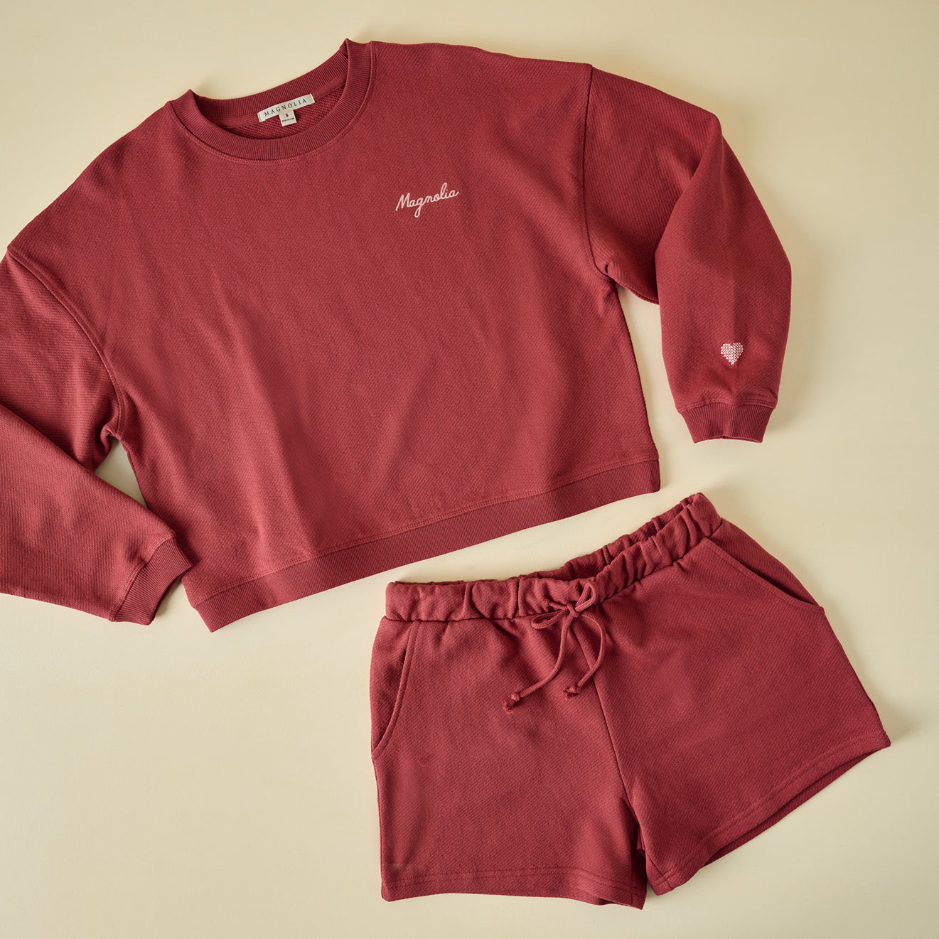 red sweatshirt with magnolia's logo on it with a matching pair of shorts.