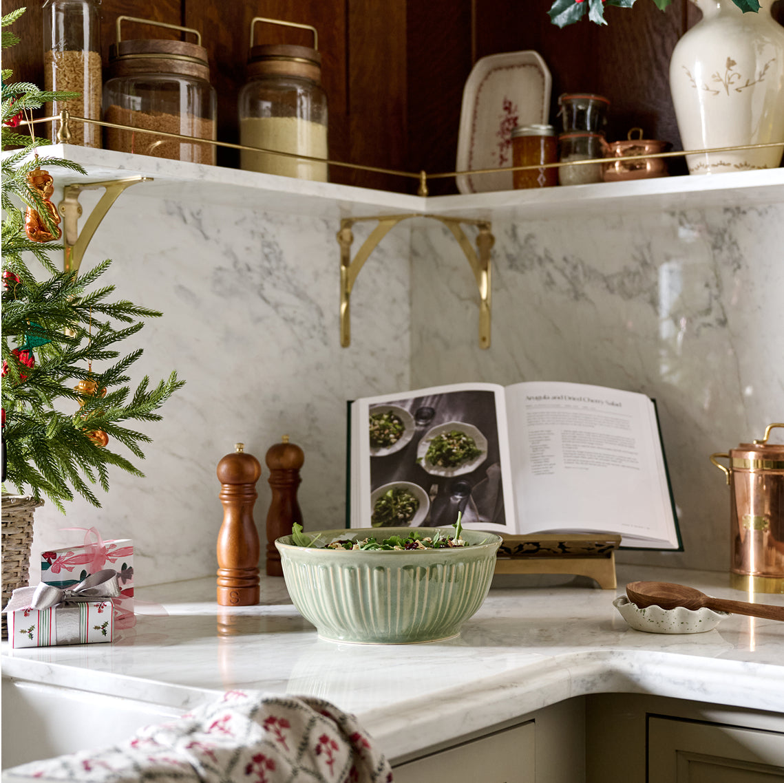 Kitchen counter with a bowl, cookbook, and decorative items on a marble countertop.