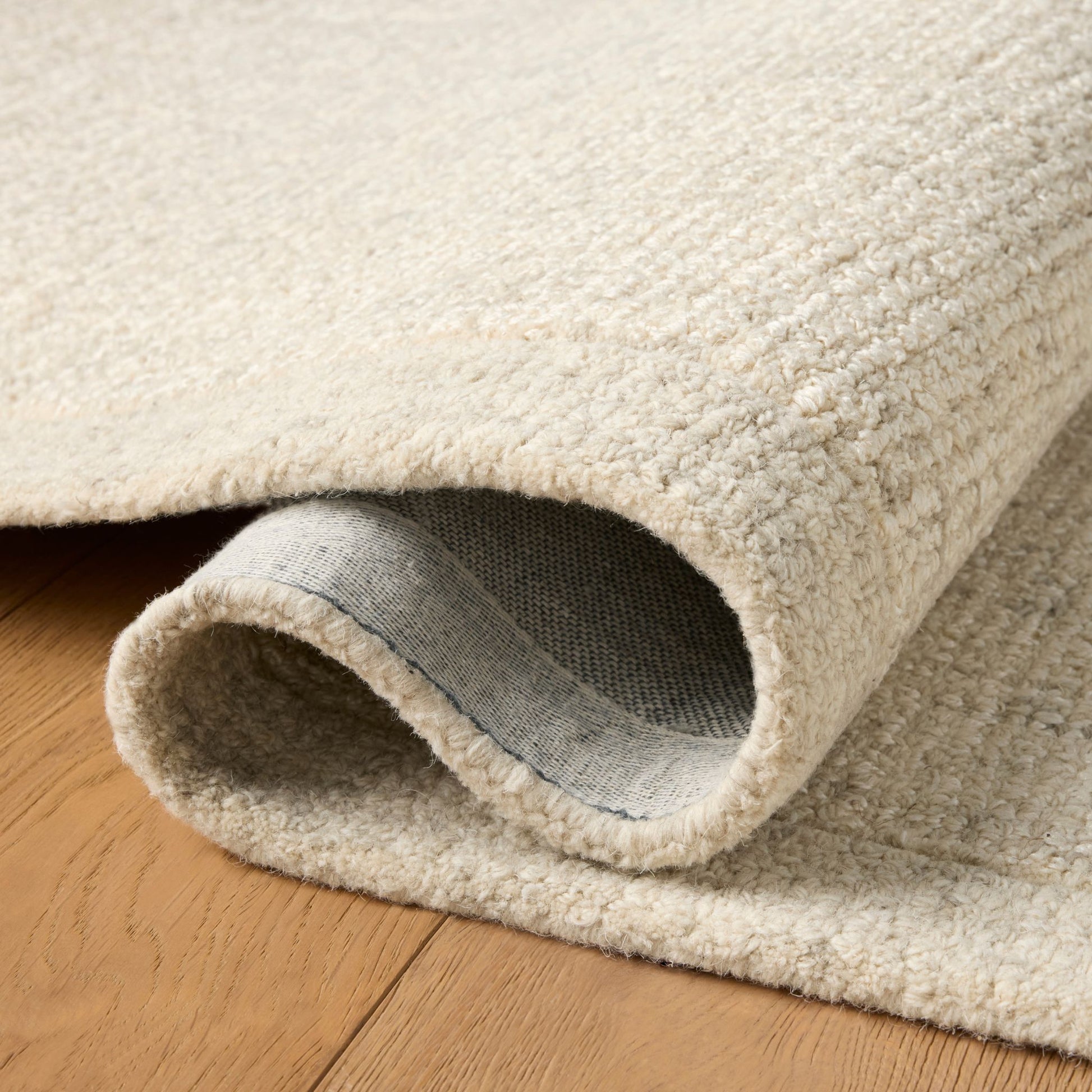 Henley Ivory Smoke Rug shown rolled/folded