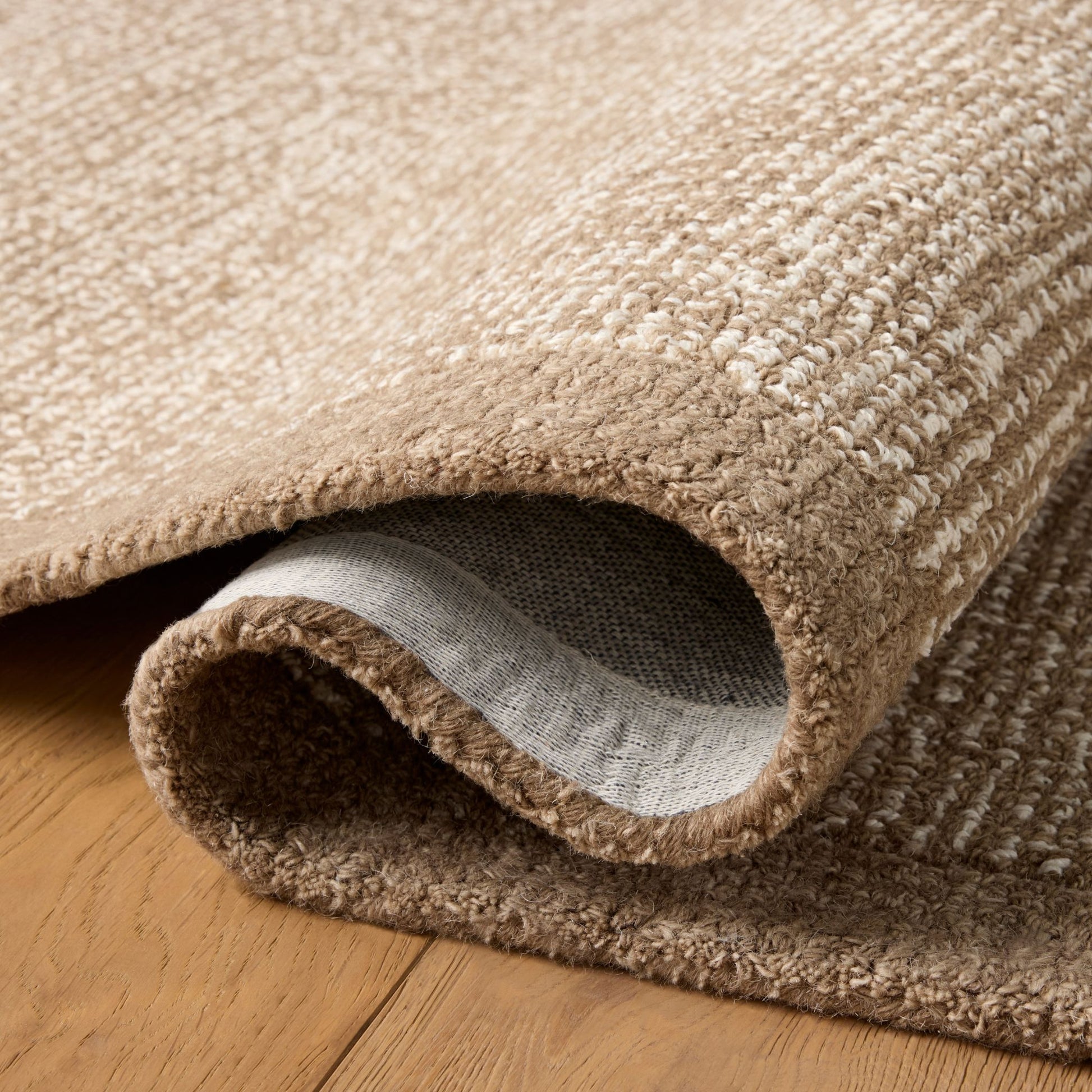 Henley Ivory Brown Rug shown rolled/folded