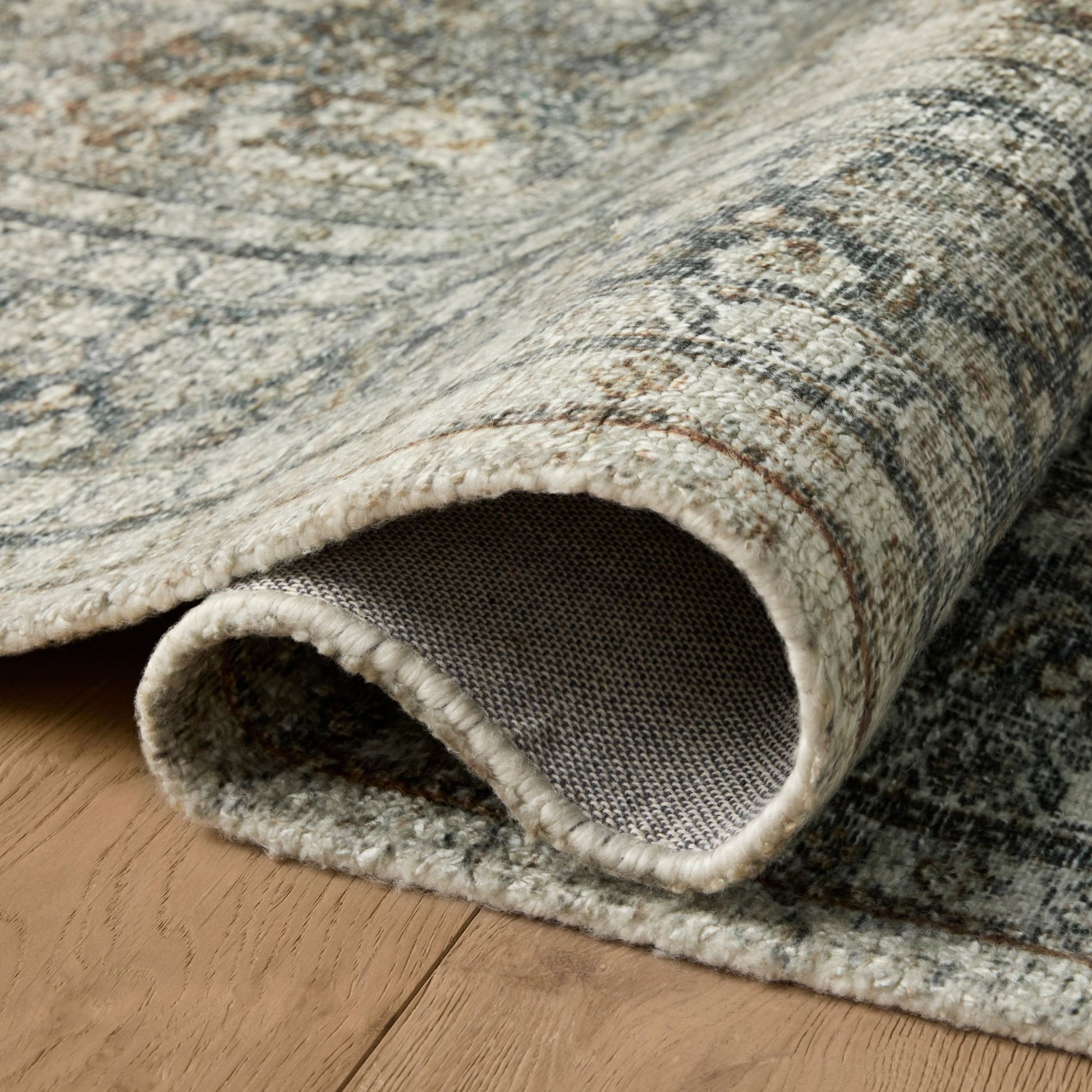 Wimberly Tobacco Rust Rug shown rolled/folded