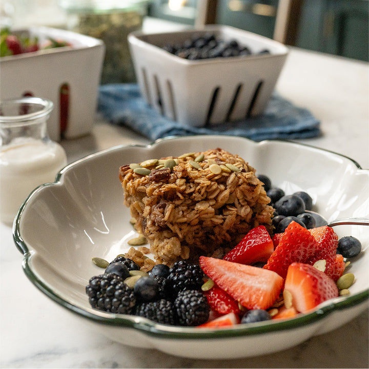 Bowl of granola with berries on a marble countertop