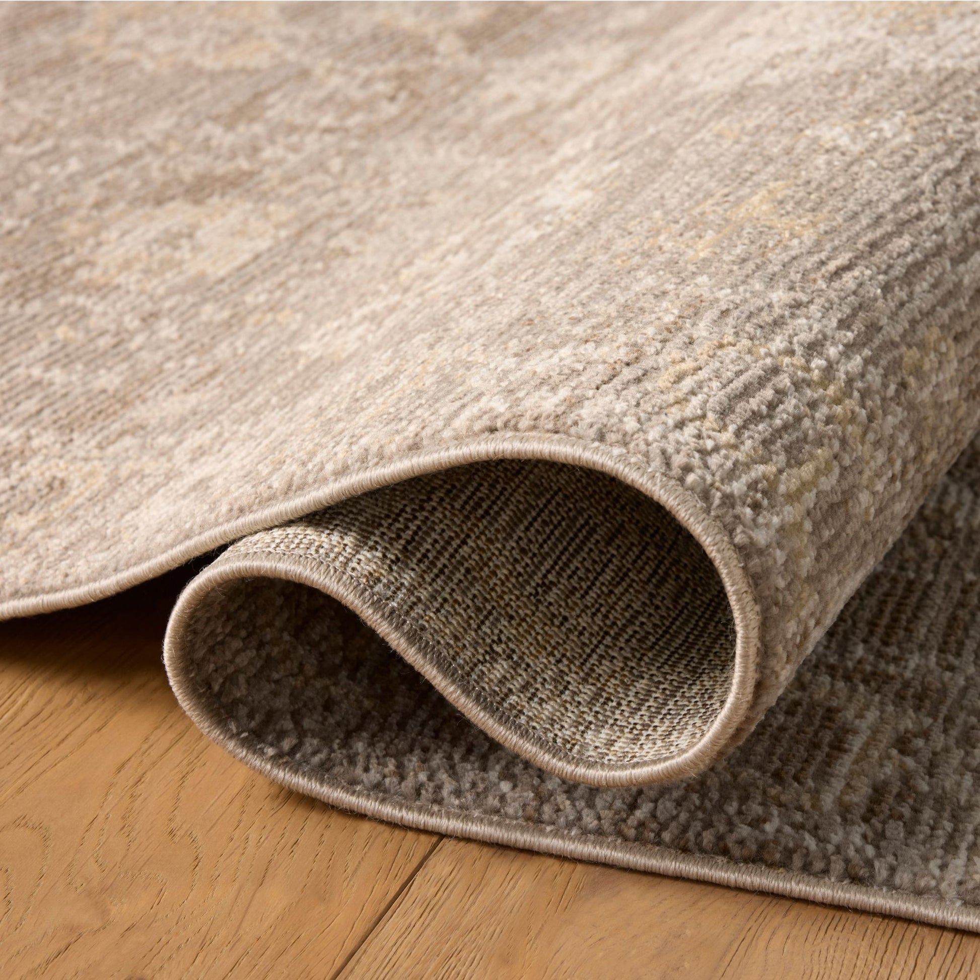 Pace Taupe Wheat Rug shown rolled/folded