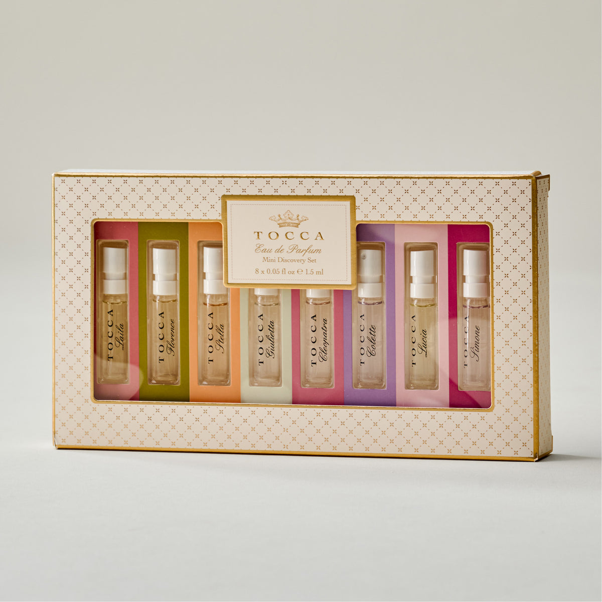 TOCCA Eau de Parfum Mini Discovery Set in a rectangular box with a window displaying eight small perfume vials in assorted pastel colors.