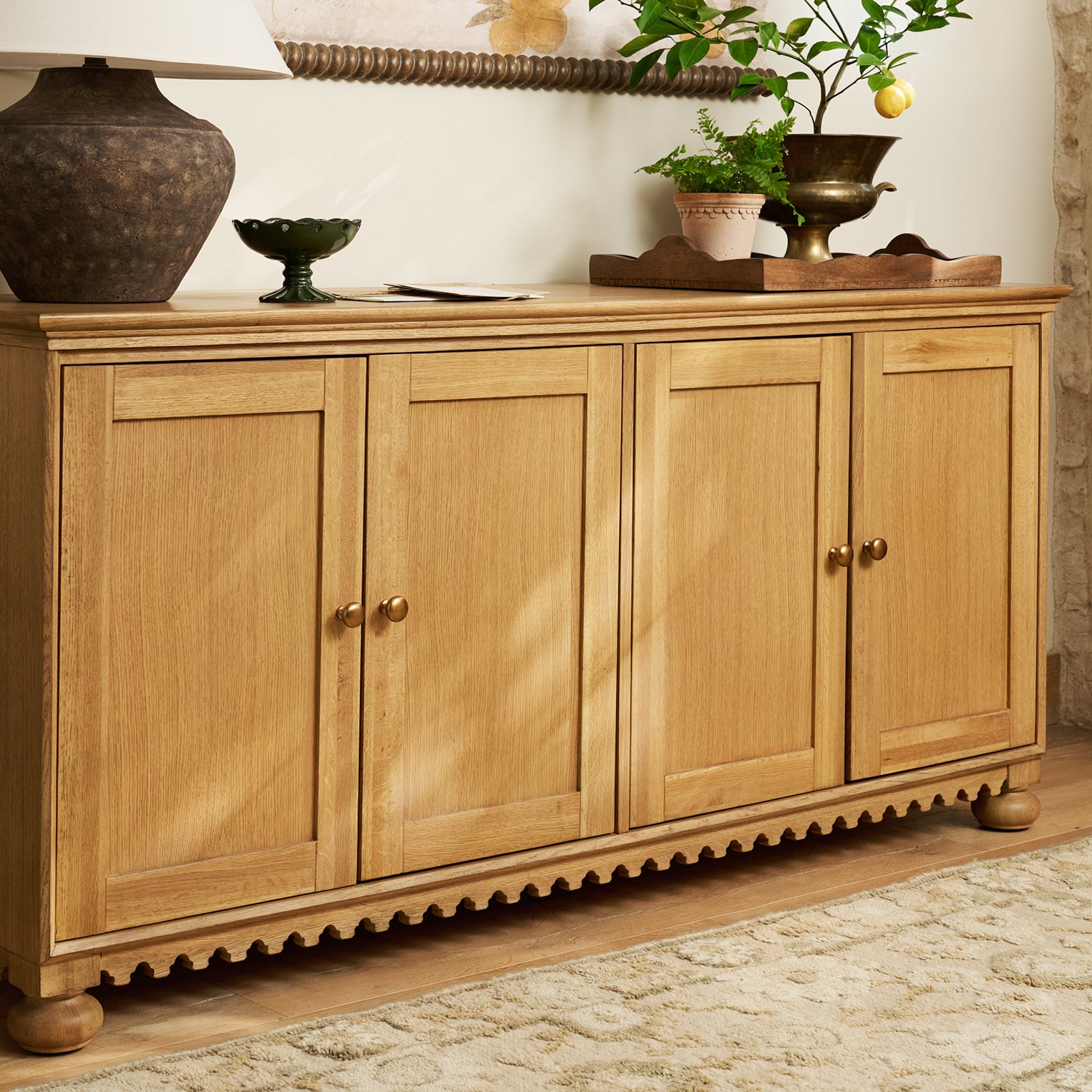 Wooden sideboard with decorative items on a stone floor