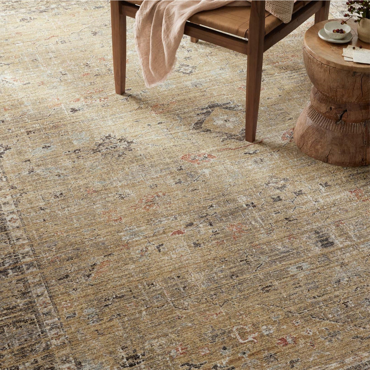 Patterned rug on a floor with a wooden chair and table in the background