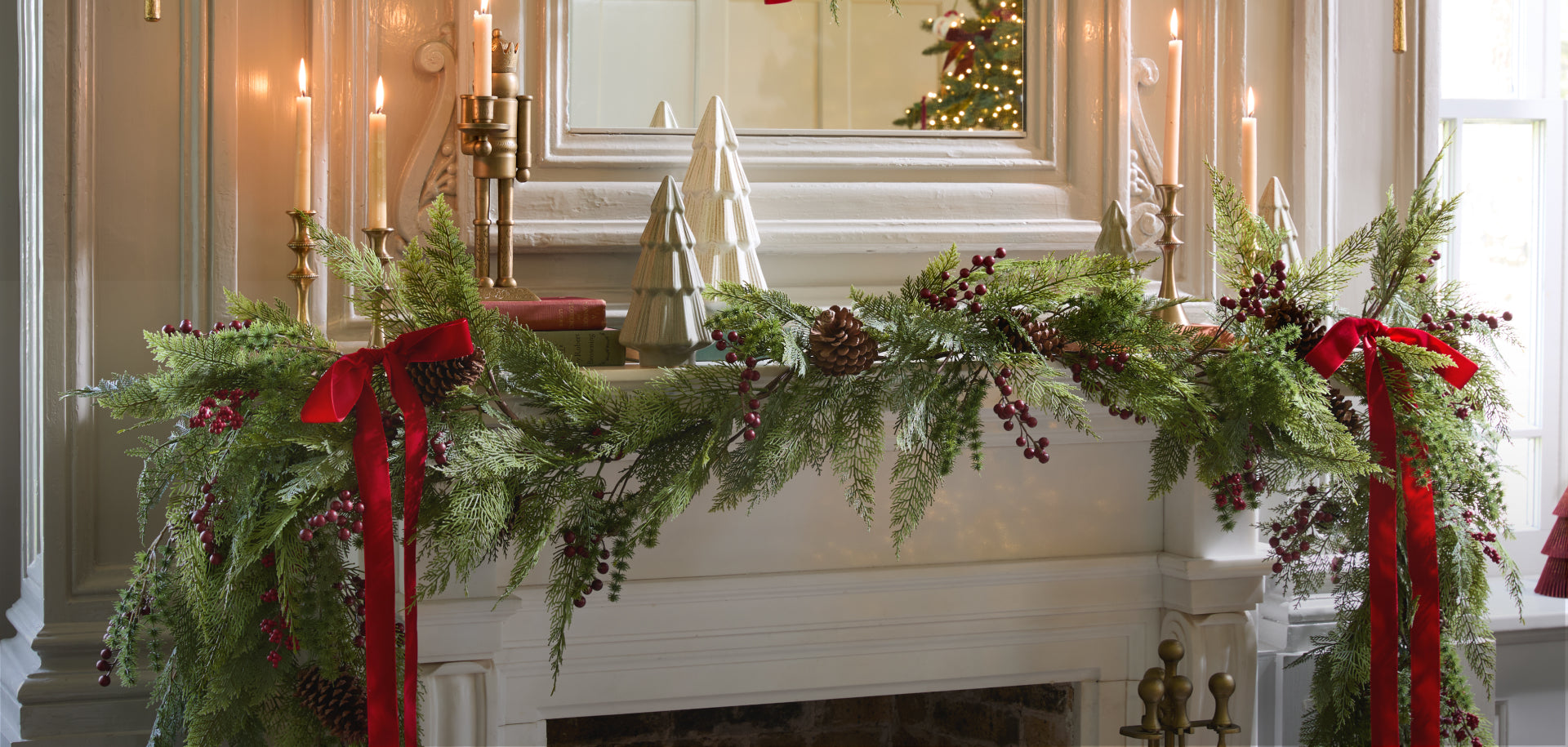 Decorative Christmas garland with red ribbons on a mantelpiece in a home setting.