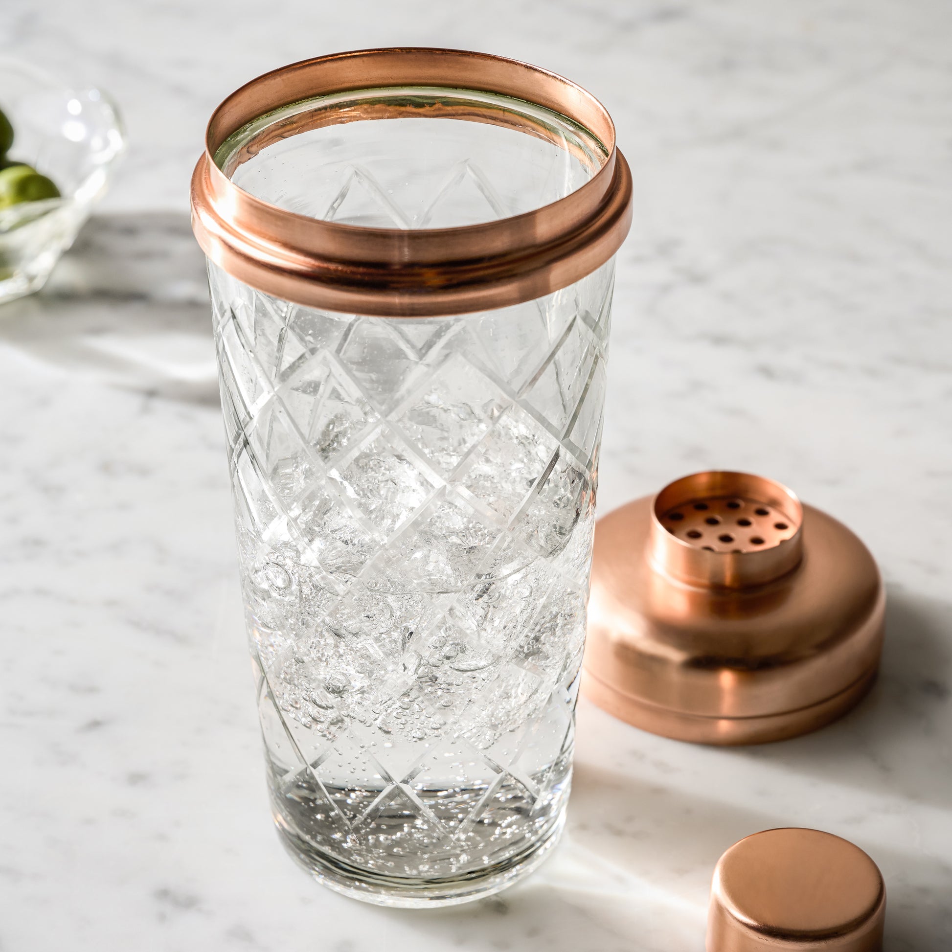 Copper and Etched Glass Shaker Bottle open on marble counter