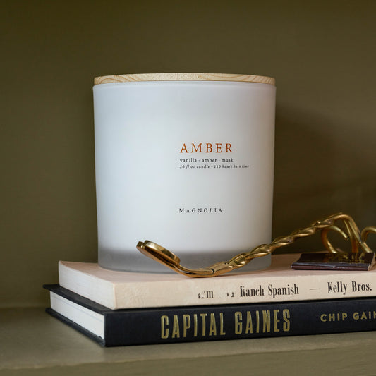 Magnolia Amber Candle on books