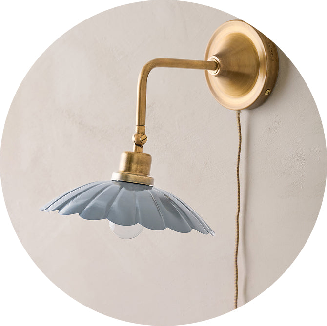 Wall-mounted lamp with a blue floral shade and gold arm on a beige background