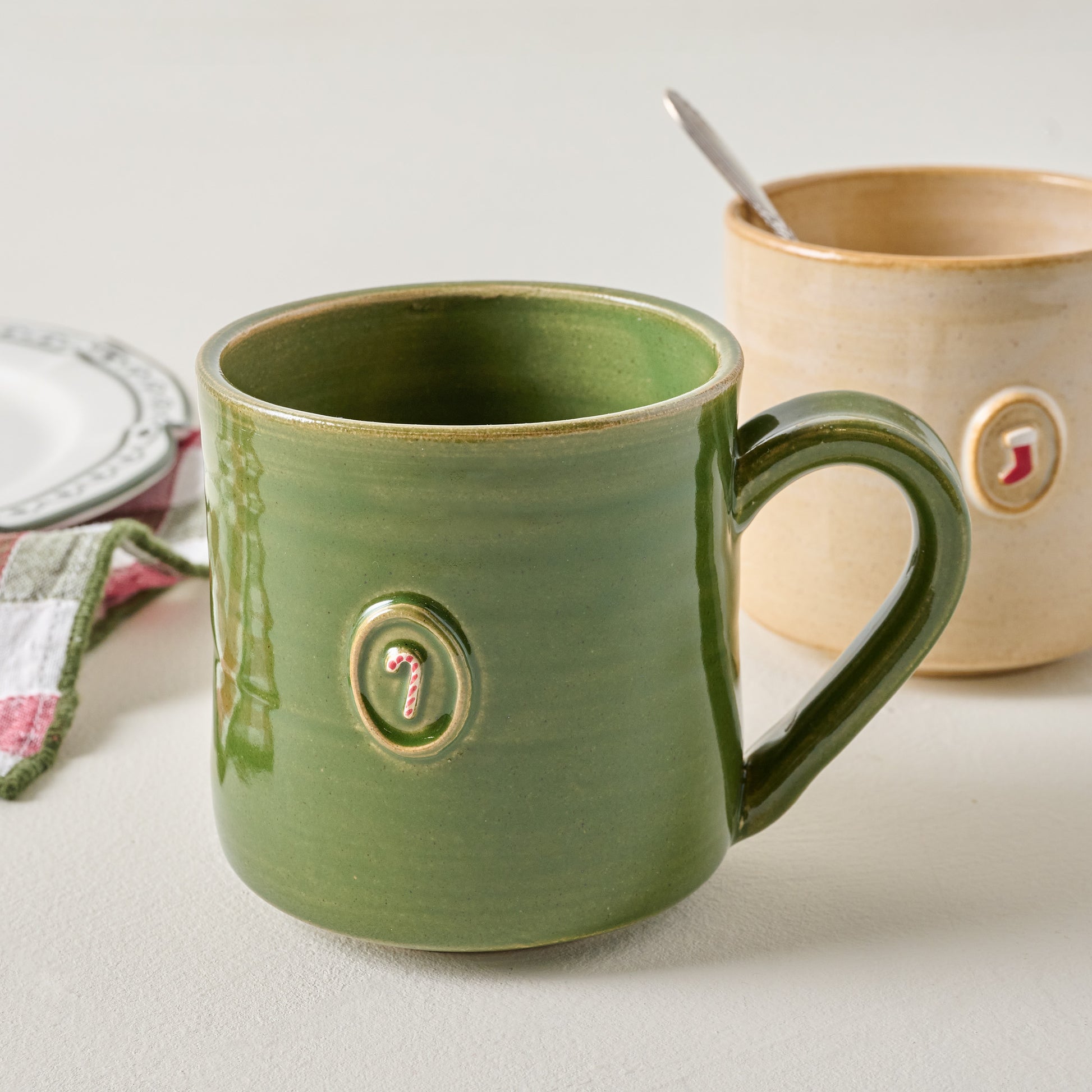 Black Oak Artisan Stocking Beige Mug shown with other tabletop and souvenir product