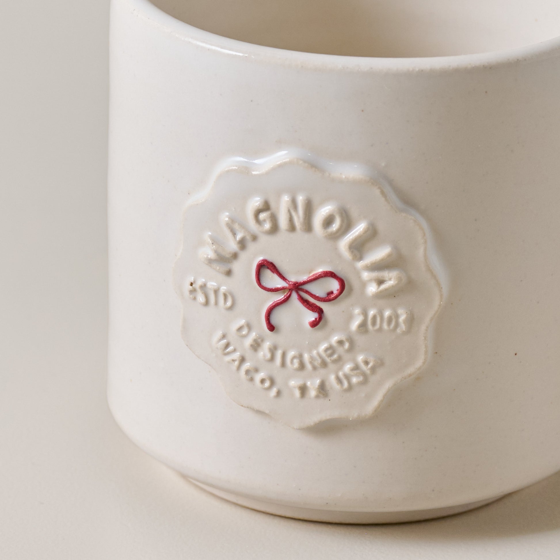 White ceramic mug with 'Magnolia' branding on a light gray background