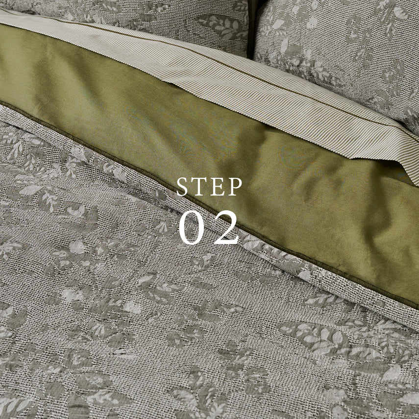 Close-up of a fabric with a floral pattern and a green strip, labeled 'STEP 02'.  Shop quilts, duvets and coverlets.