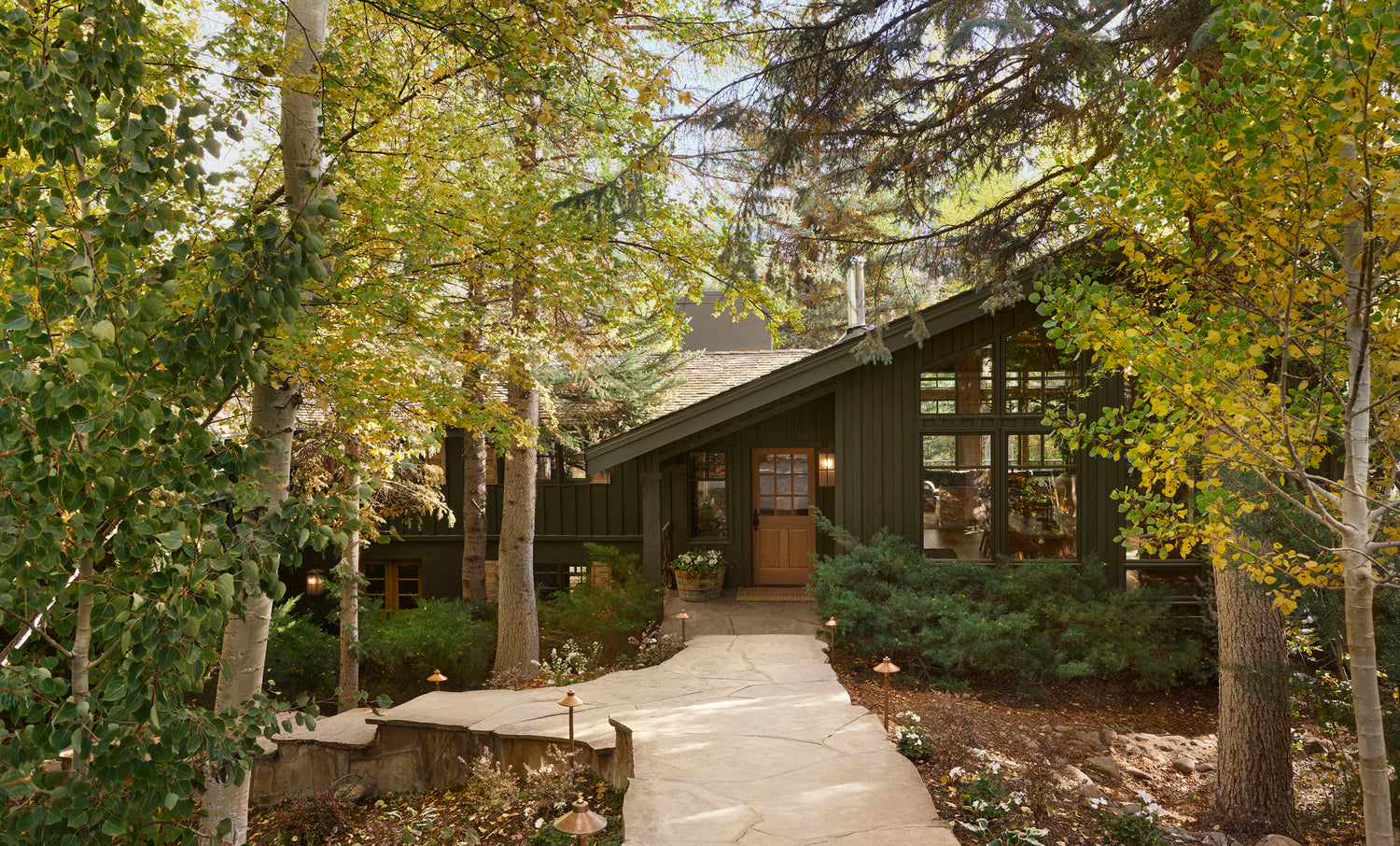 Wooden cabin surrounded by trees with autumn foliage