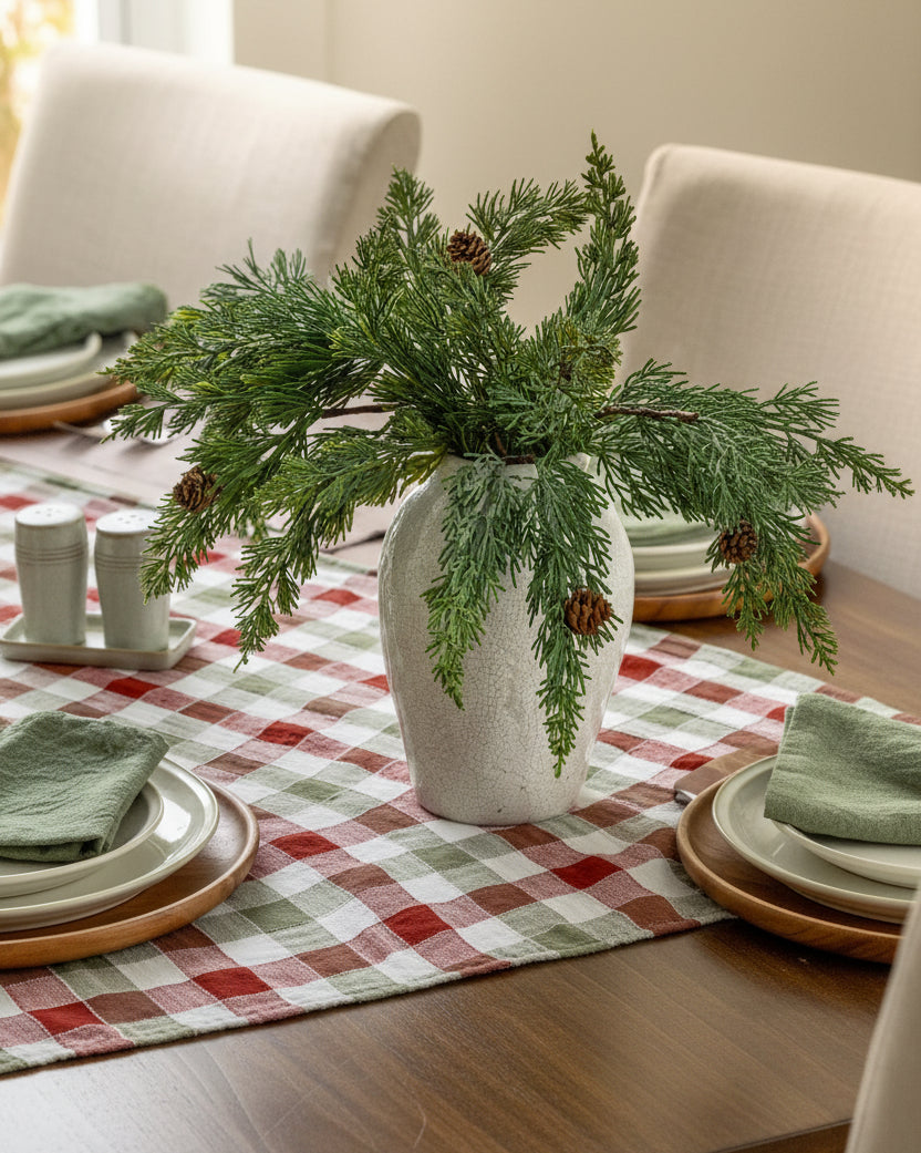 Maeve Pine Spray in a vase on a table