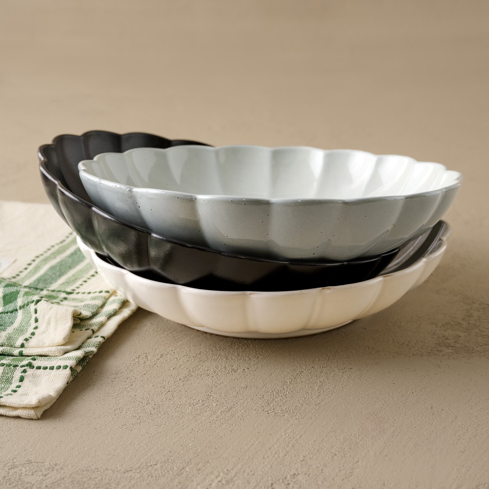 Oversized Cream Scalloped Serving Bowl shown with black and grey oversized scalloped serving bowls