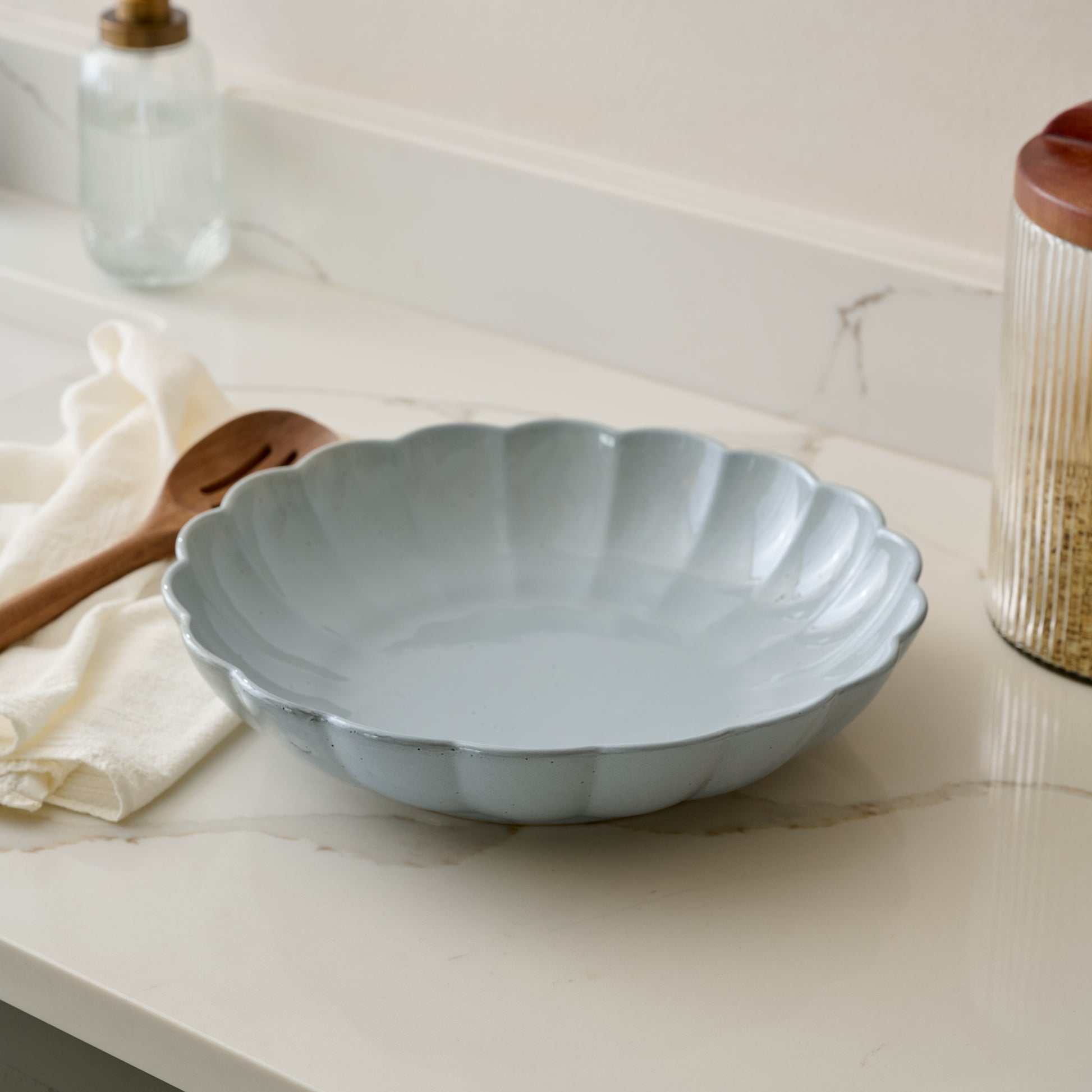 Oversized Grey Scalloped Serving Bowl shown on kitchen counter