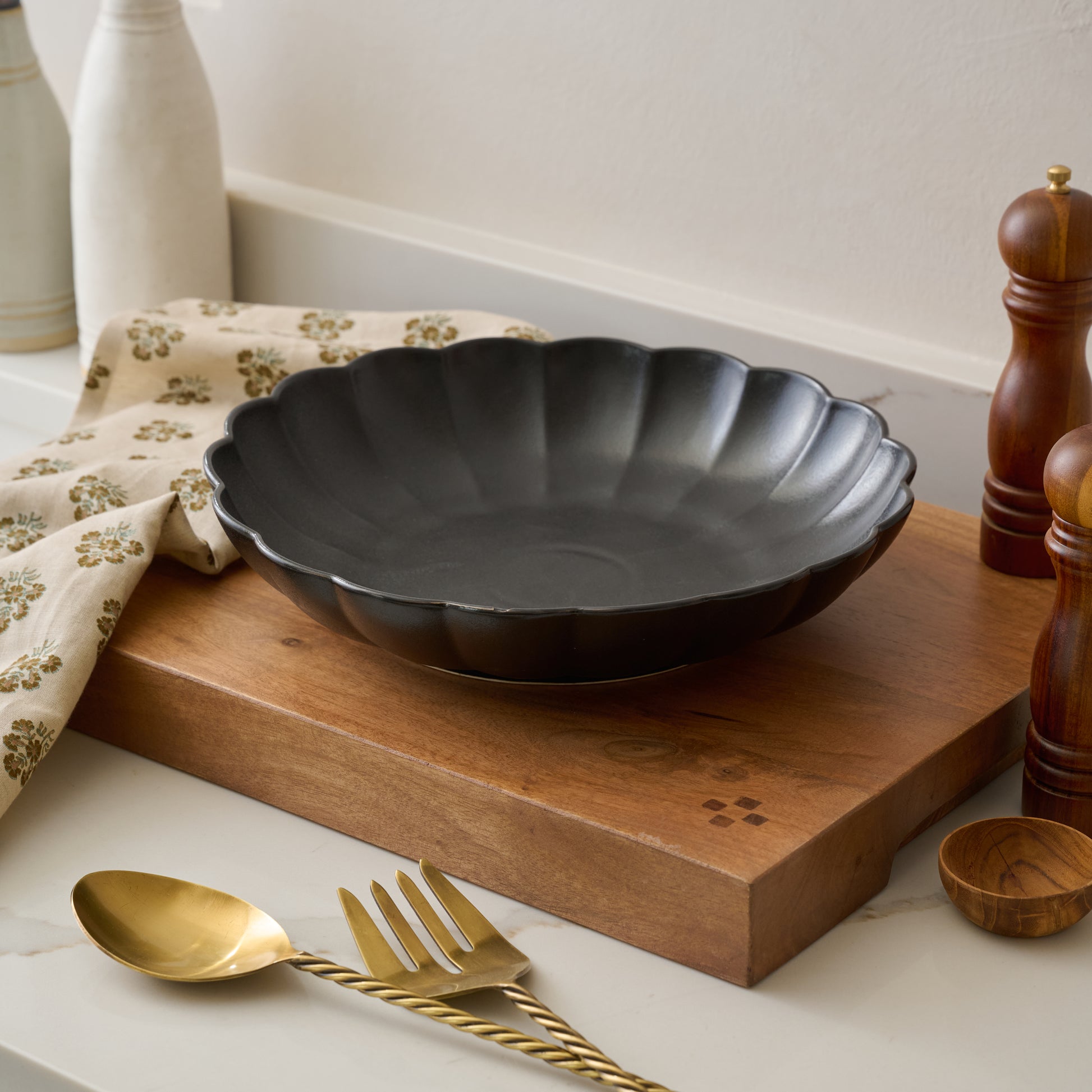 Oversized Black Scalloped Serving Bowl shown on kitchen counter
