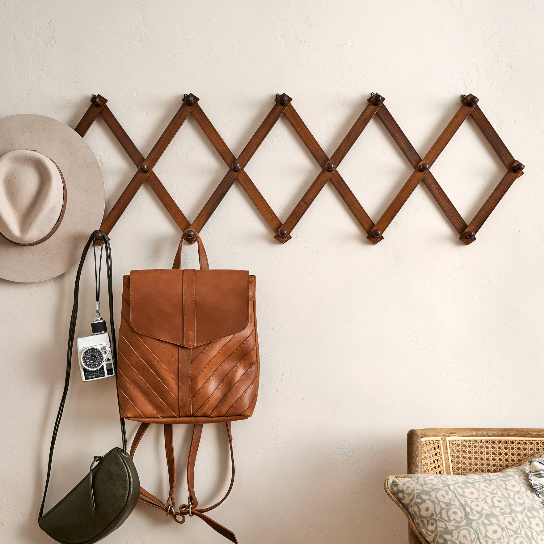 Accordion Wooden Wall Hook on a wall with accessories and handbags hanging