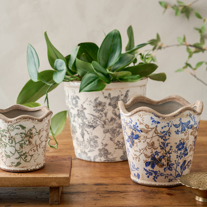 Green Scalloped Distressed Planter on a table next to other similar planters