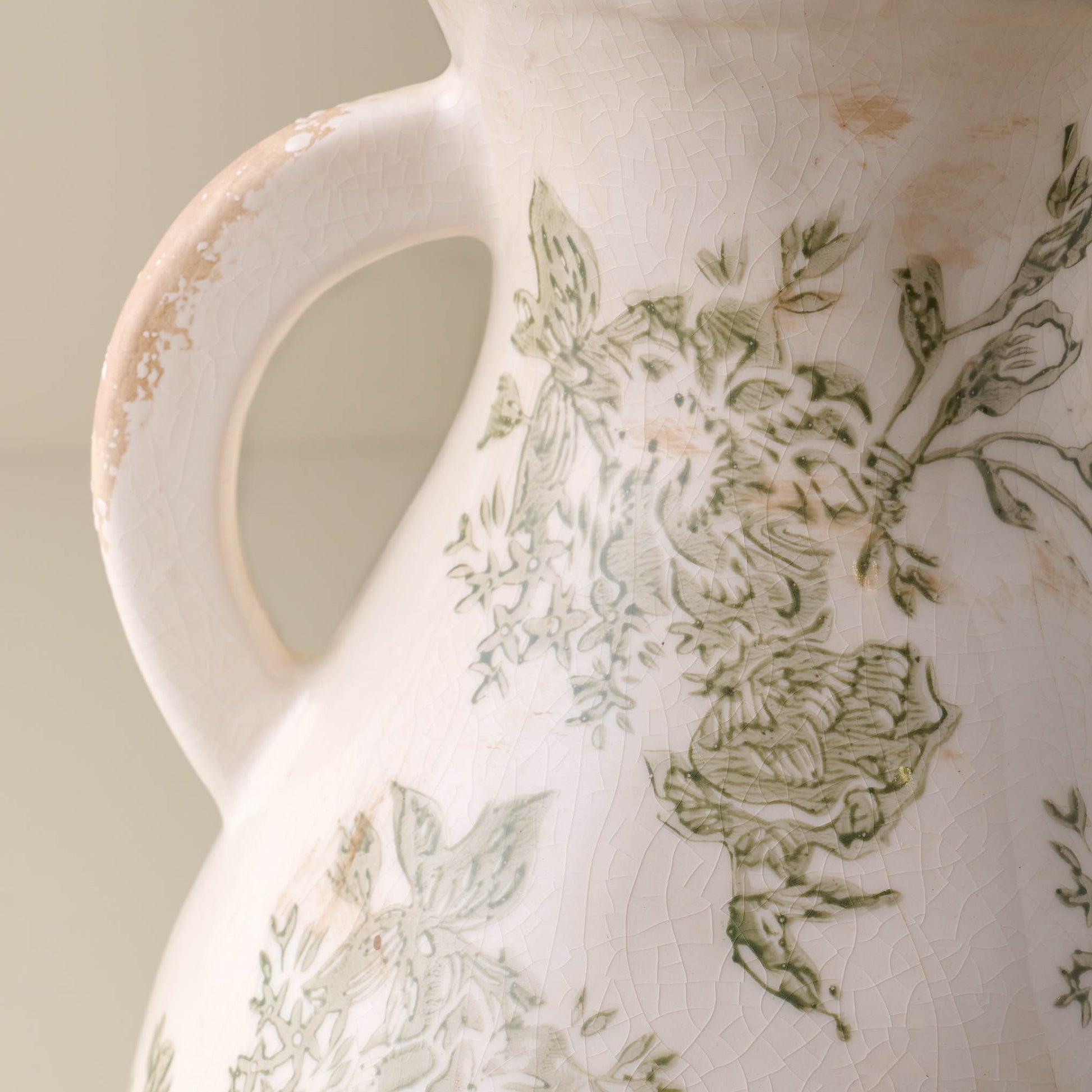 Close up of distressed vase Green and White floral detail