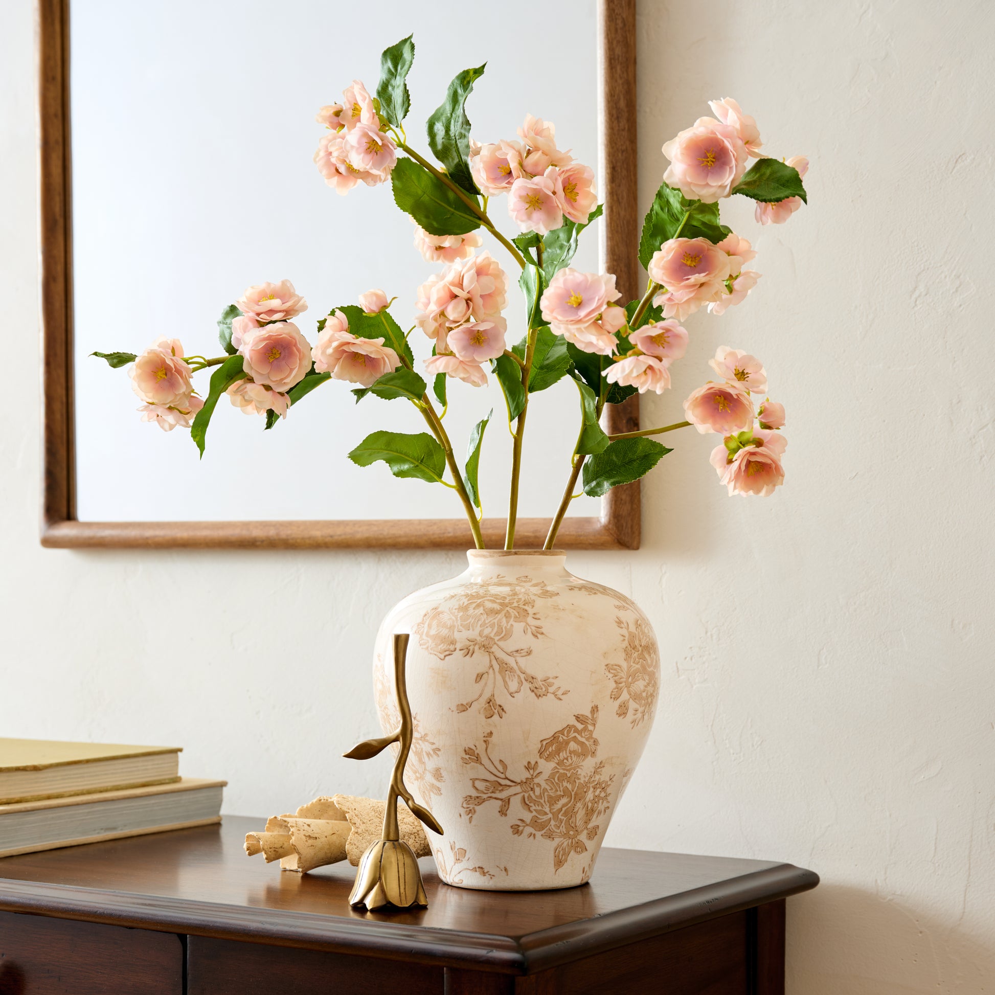Floral Antique Brass Bell paired with distressed ceramic vase and florals on top of console table