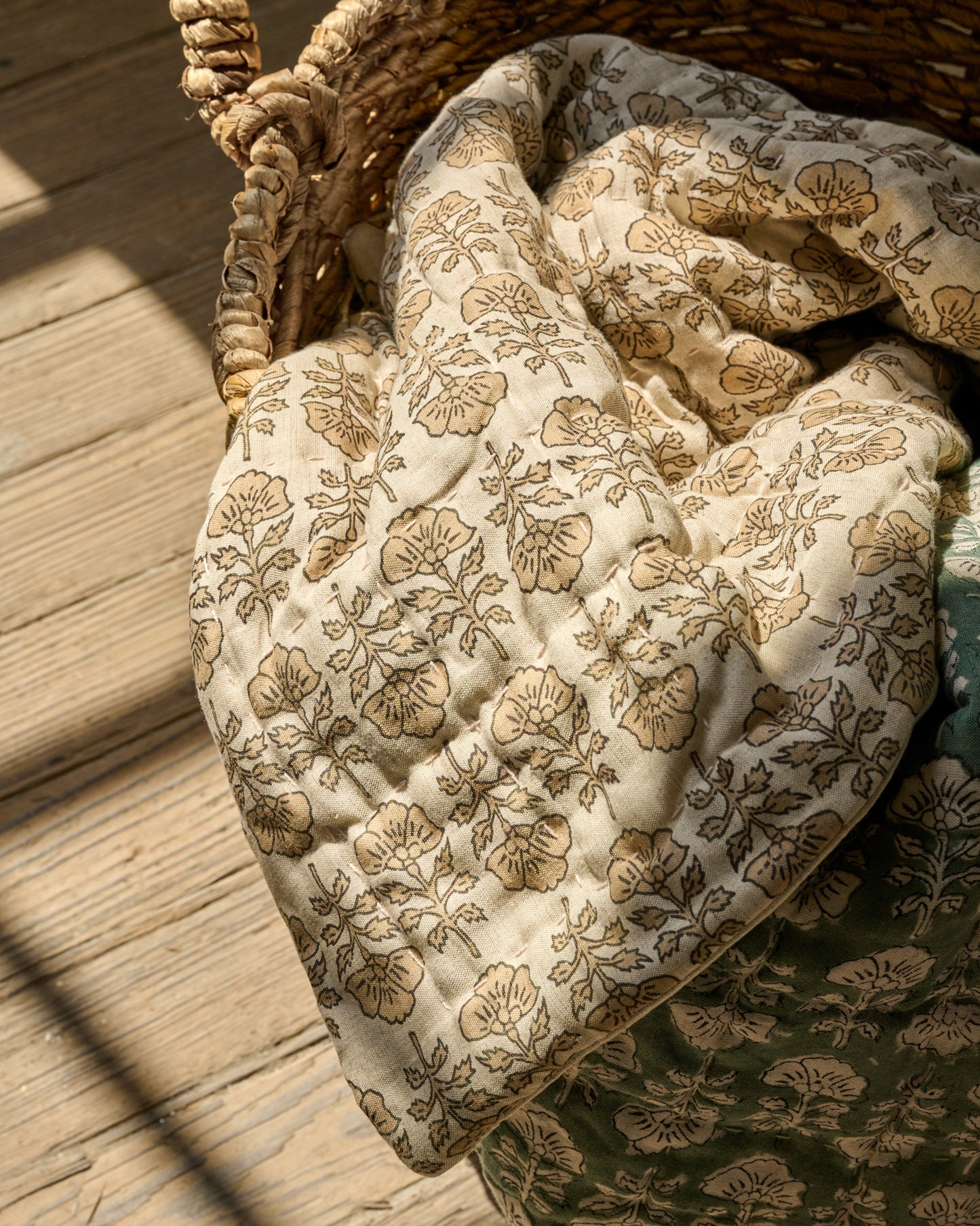 Flora Block Print Quilt - Natural laying inside basket