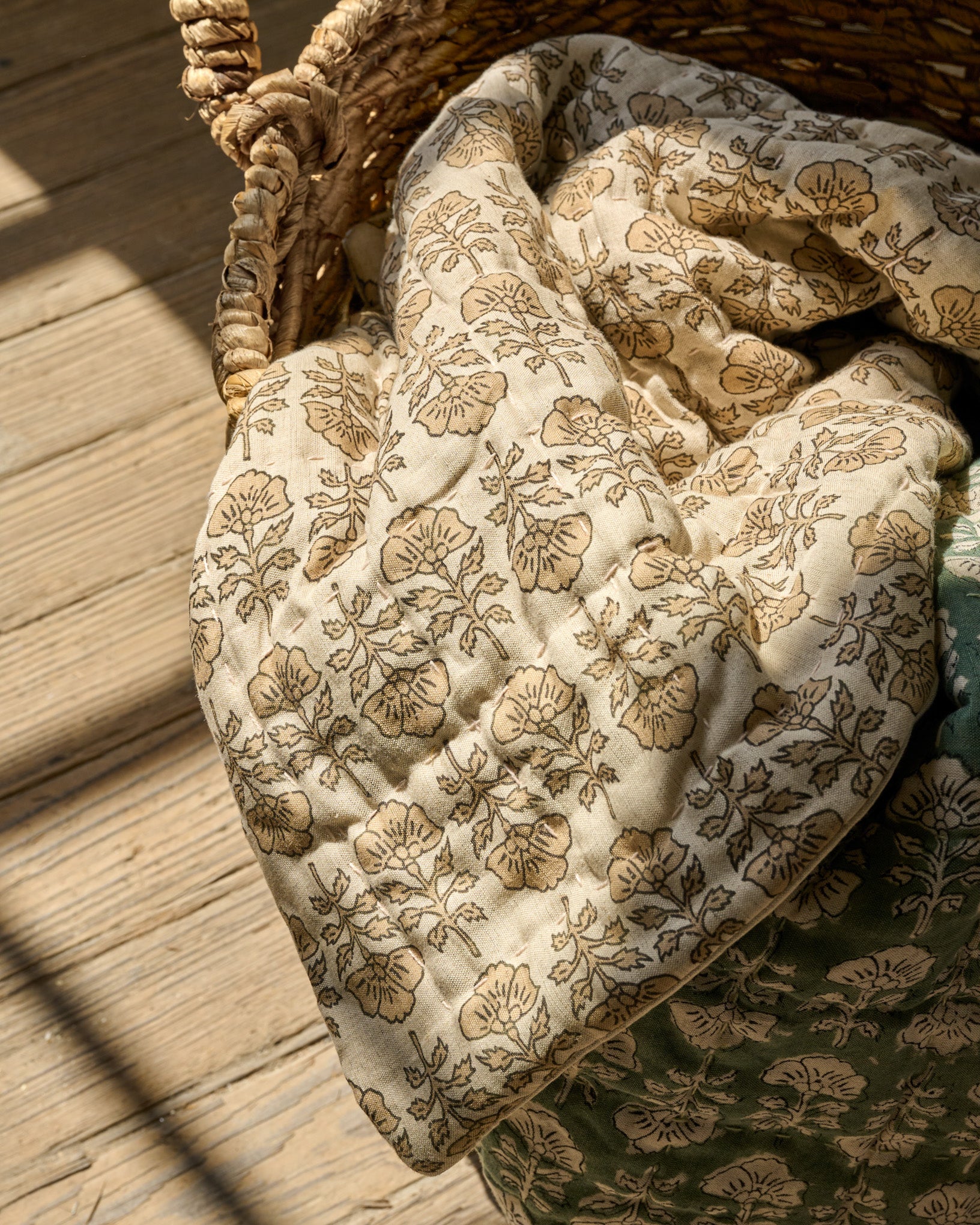Flora Block Print Quilt - Natural laying inside basket
