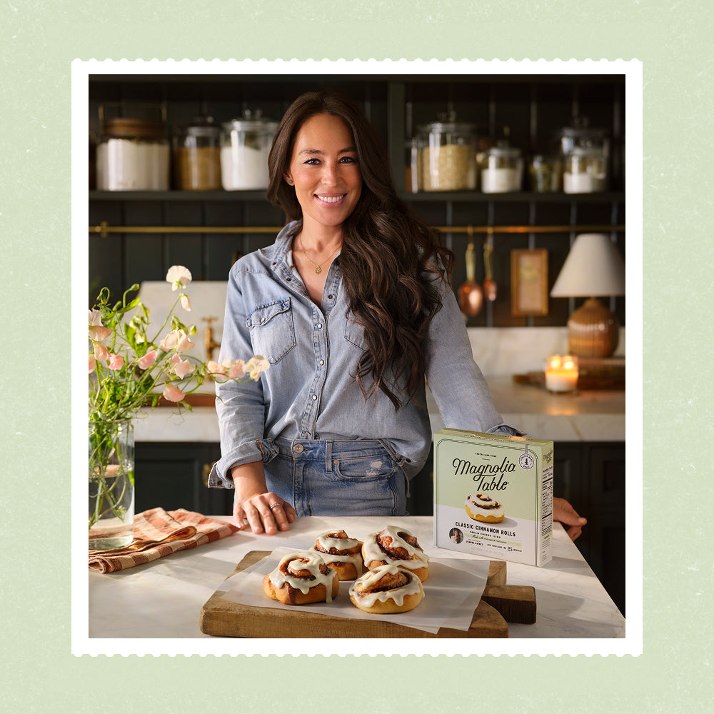 Joanna Gaines standing behind her Magnolia Table cinnamon rolls.