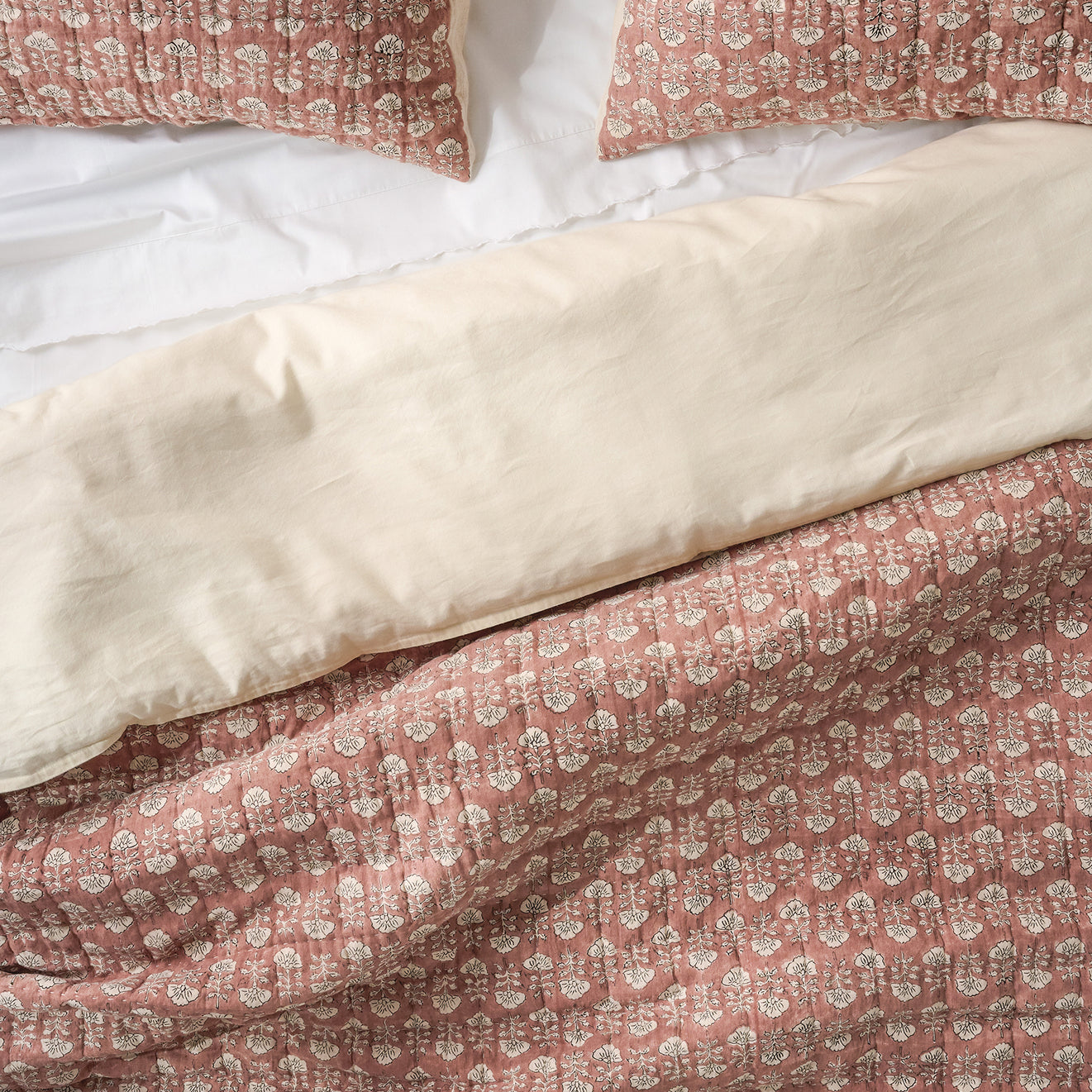 Flora Clay patterned pillows and duvet cover on a bed.