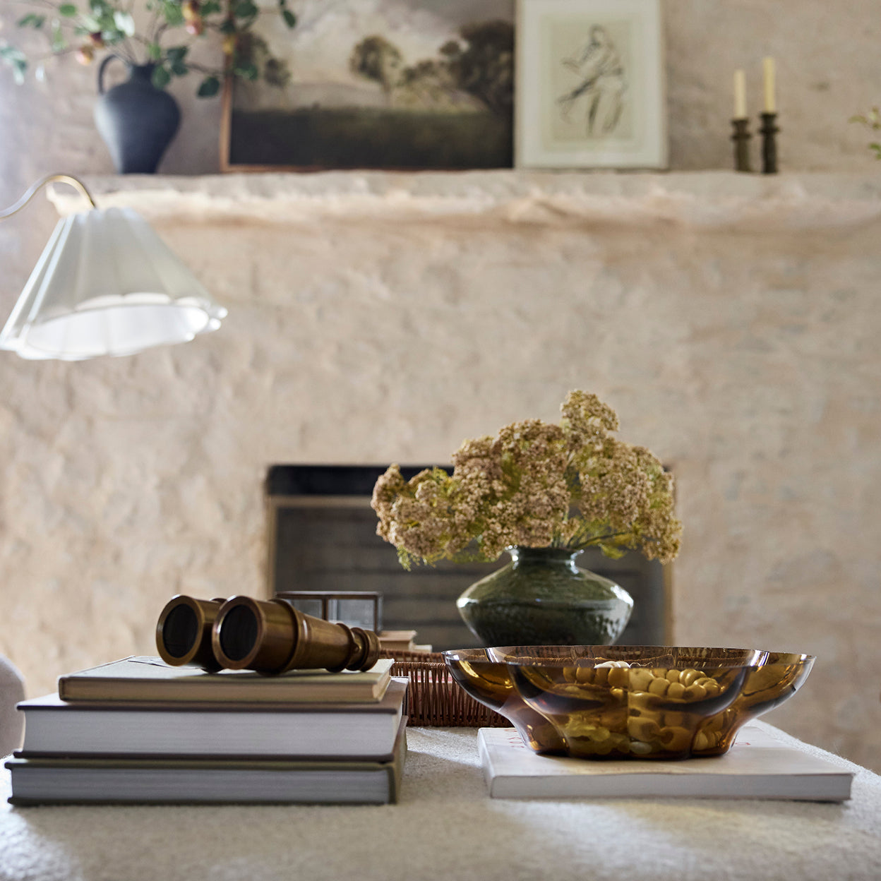 Decorative items on a table with a fireplace in the background
