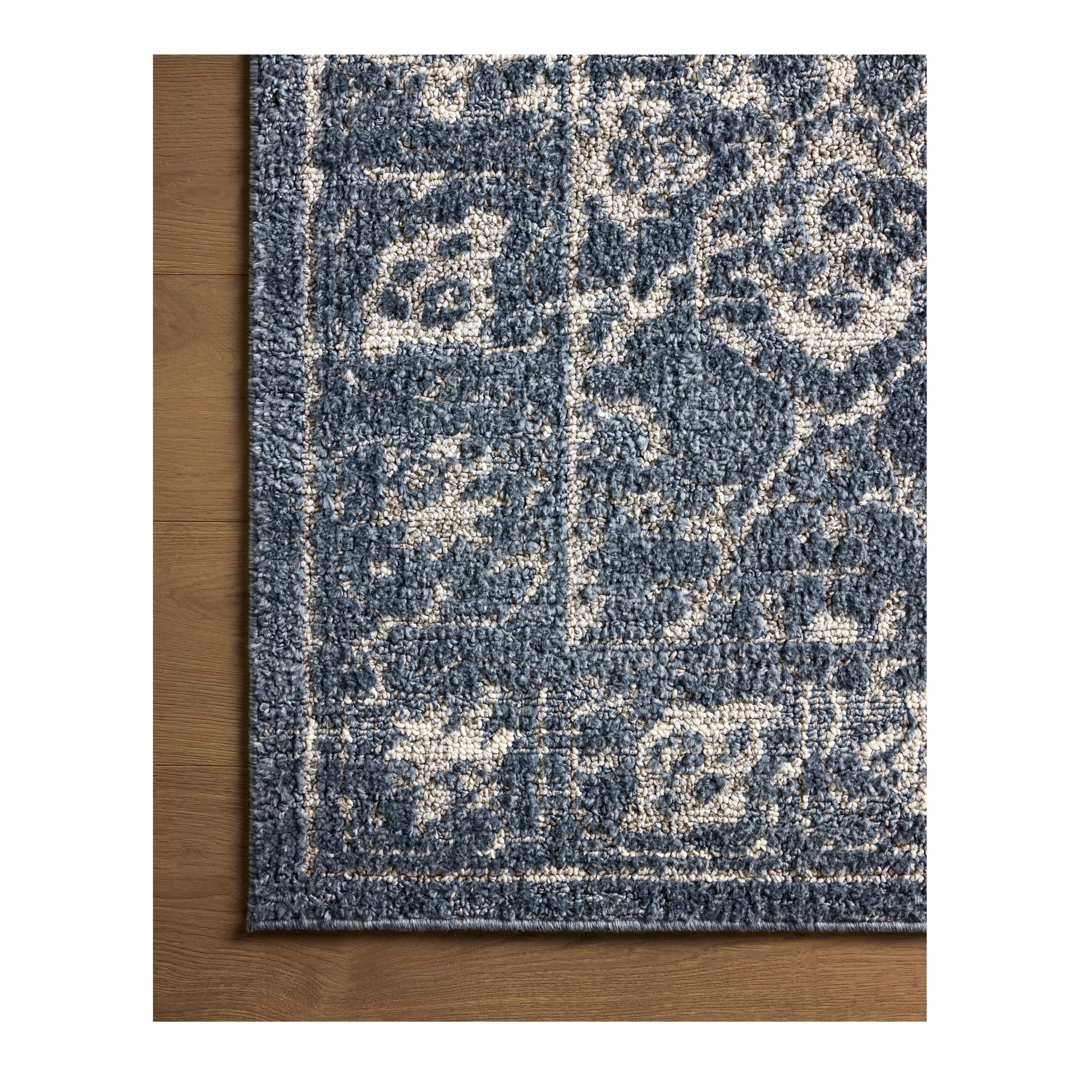 Gigi Navy Stone Rug close up of corner on wood floor
