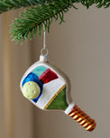 Painted Glass Pickleball Ornament shown hung on branch