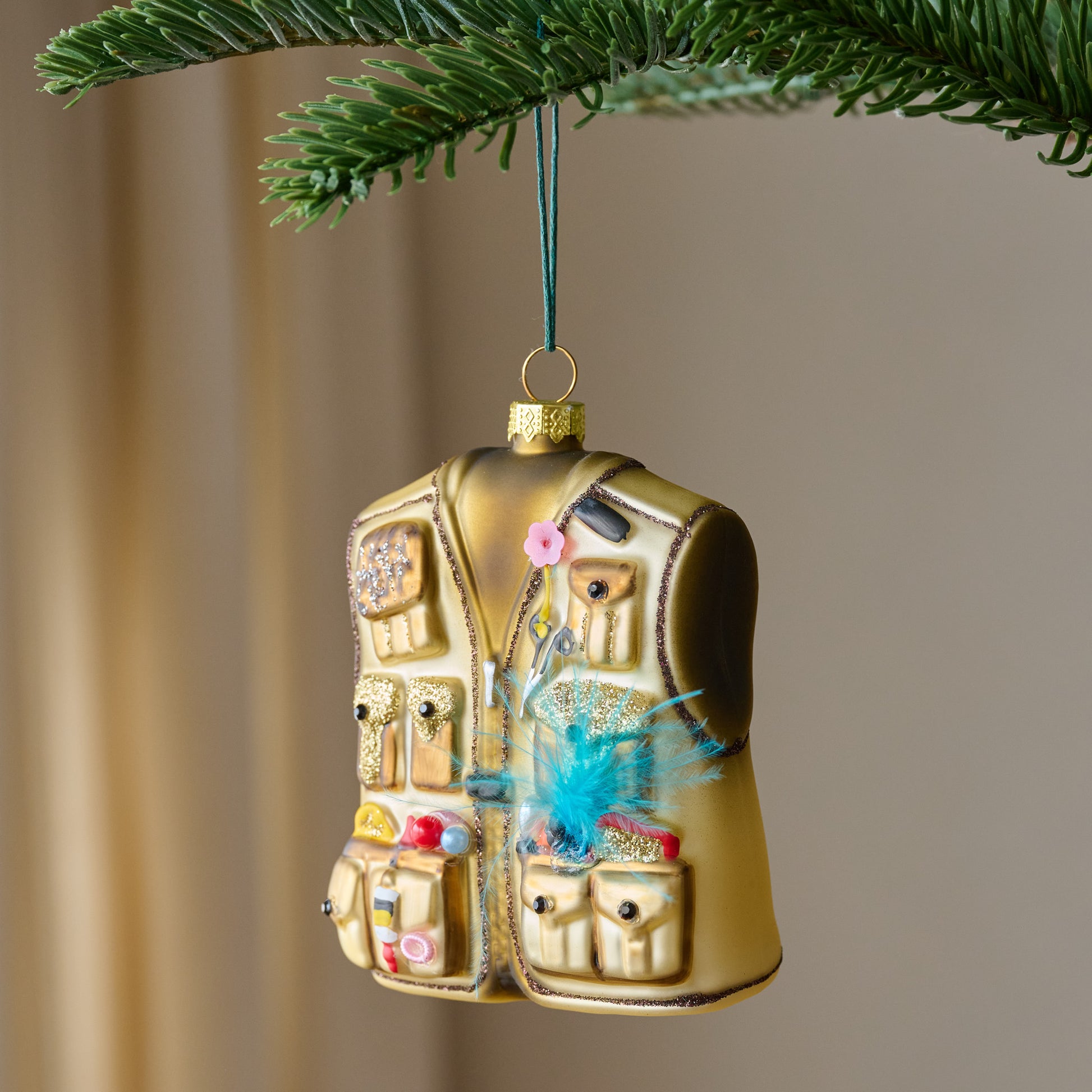 Fisherman's Favorite Vest Ornament shown hung on tree