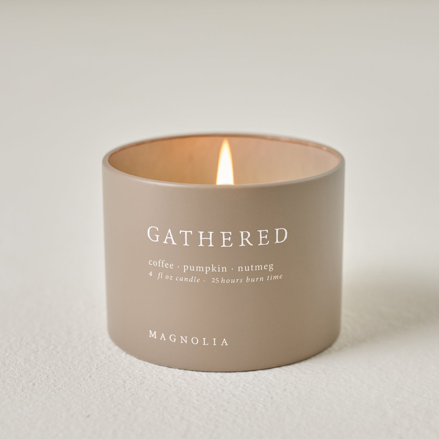 Magnolia Gathered Candle Tin shown burning