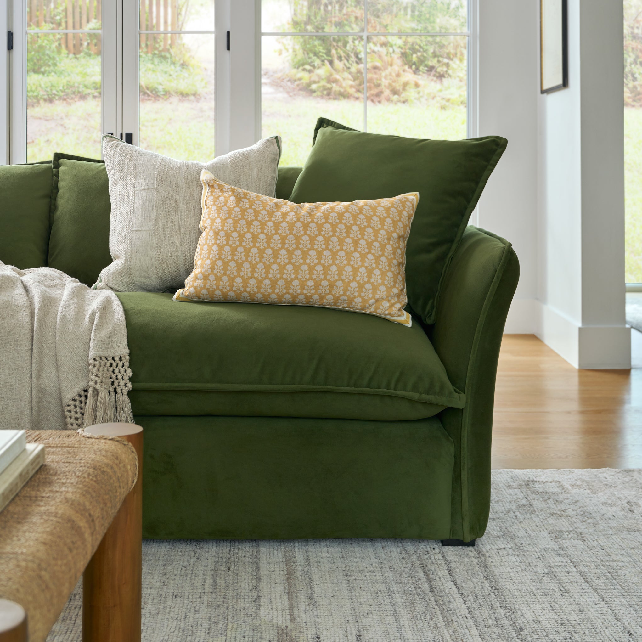 Green sofa with patterned cushions in a living room setting