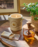 Magnolia Honeycomb Candle next to matches and a honey pot