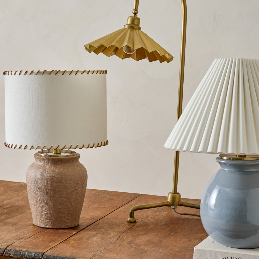 Three decorative lamps with different designs on a wooden surface.
