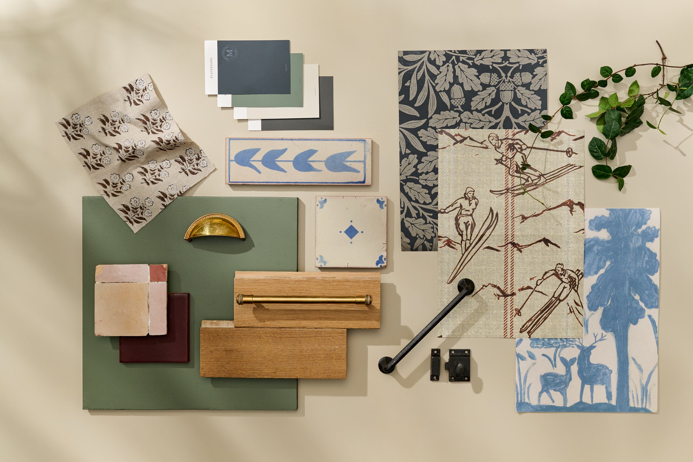 Collection of decorative items including patterned paper, a green board, wooden blocks, and a black rod on a beige background.