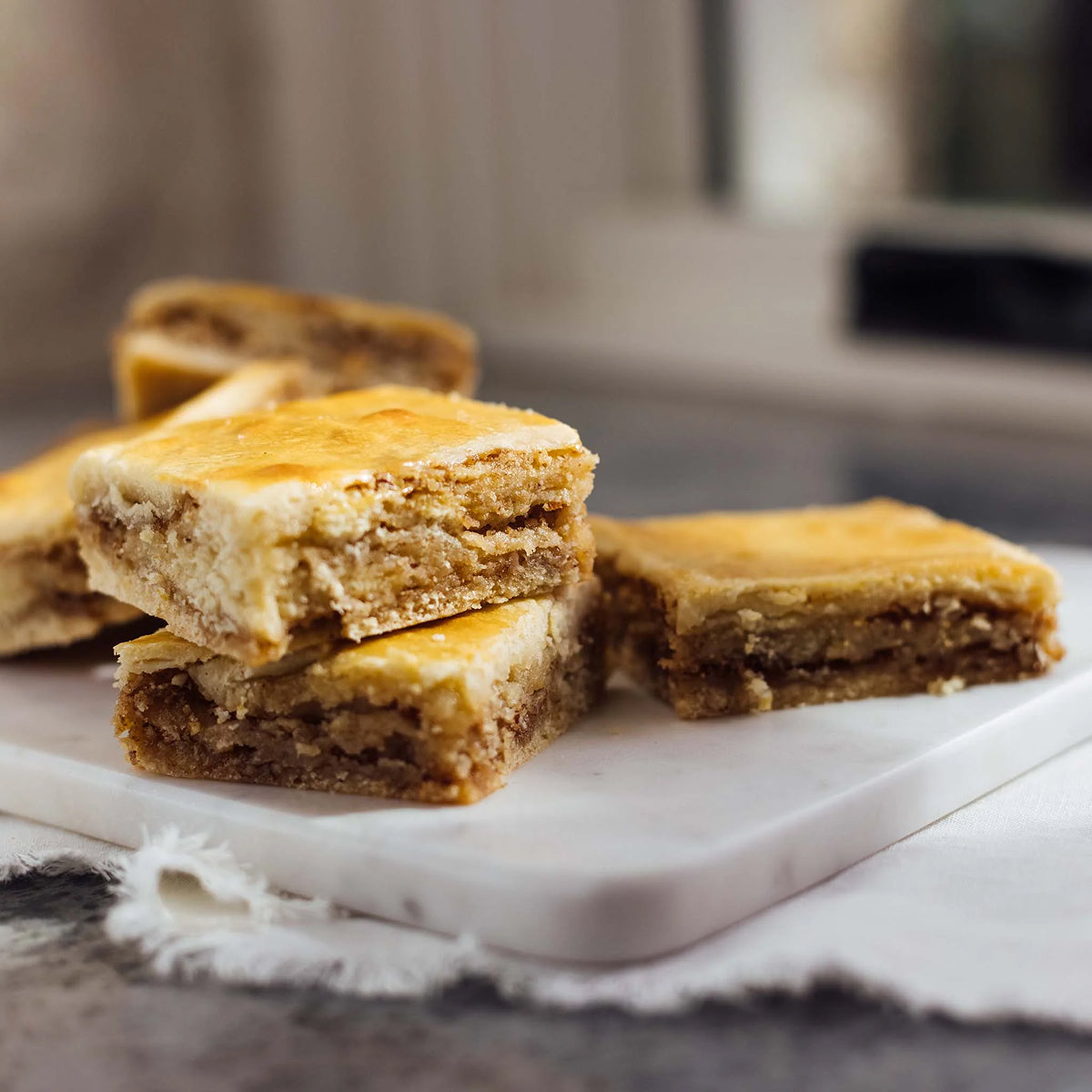 Cinnamon Squares on a marble surface with a blurred background.