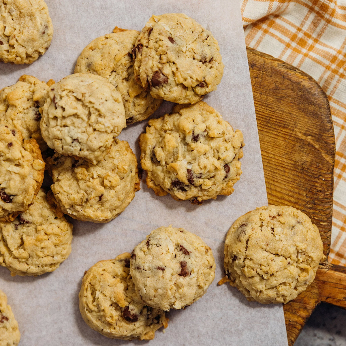 Ranger Cookies on a wooden board with a checkered cloth in the background.